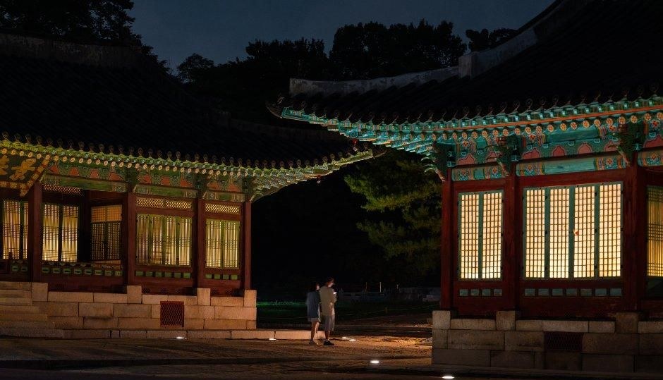 어두운 밤에 조명이 켜진 한옥 전각과 마당 풍경