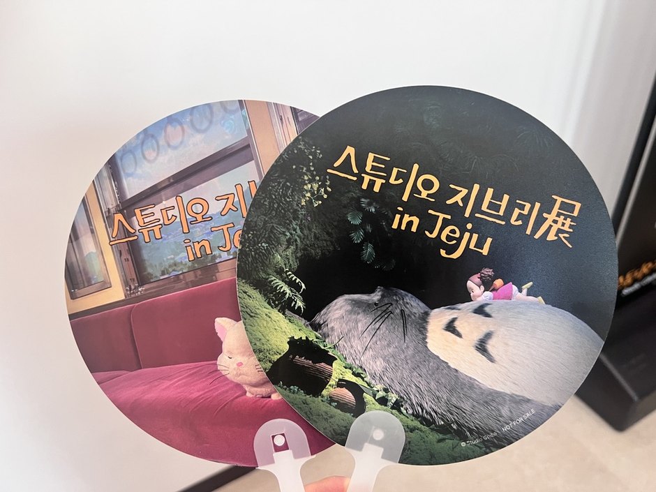 스튜디오 지브리展 in Jeju 로고와 토토로 장면, 고양이버스 창가 장면이 인쇄된 비매품 원형 부채 두 개