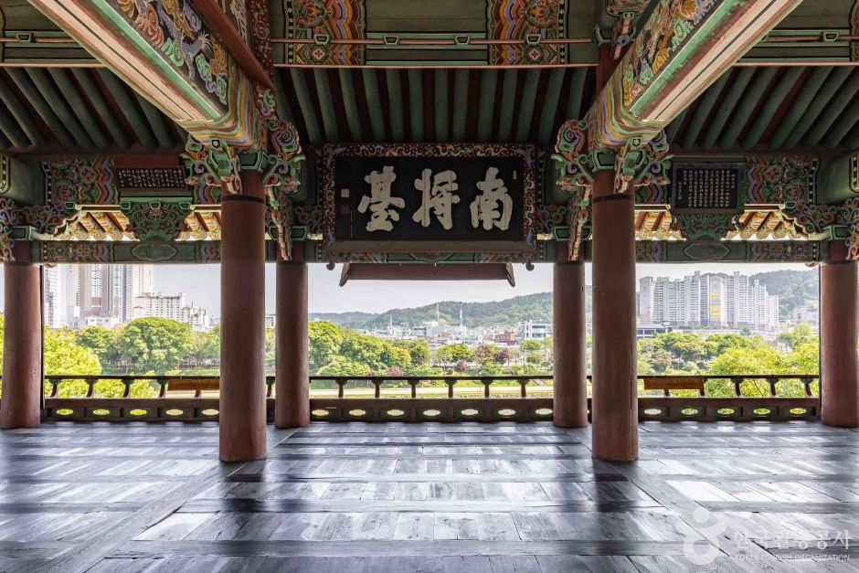 촉석루 누각 기둥 사이로 남강과 진주 시내가 내다보이는 풍경