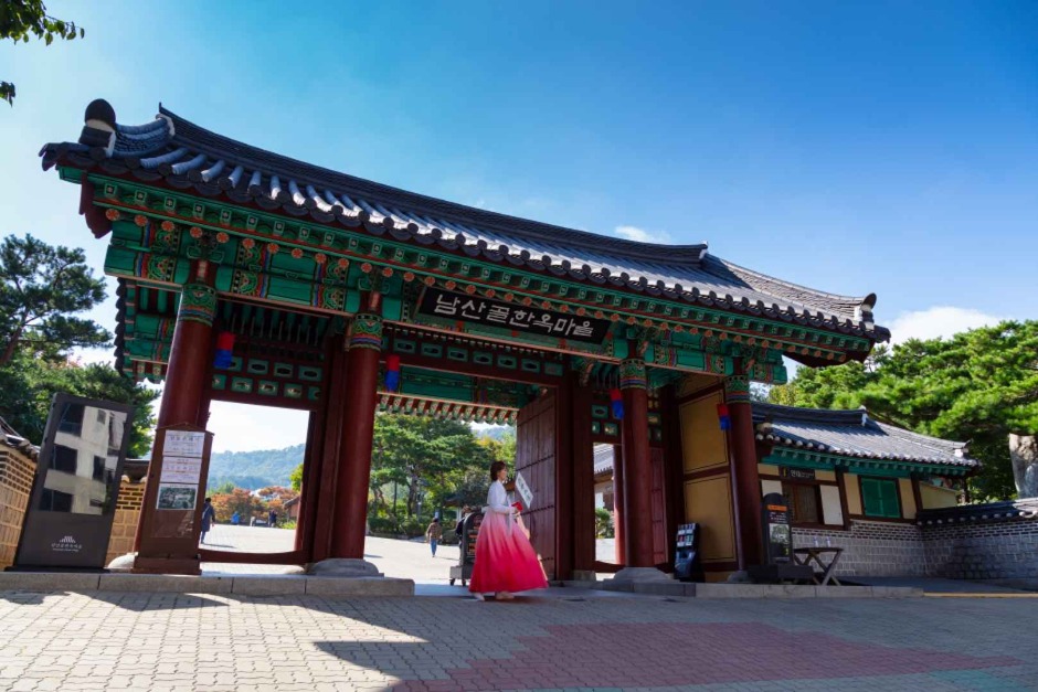 푸른 하늘 아래 남산골한옥마을 전통문과 방문객