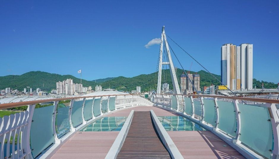양산천 위로 길게 이어진 구름다리 보행로와 멀리 보이는 산