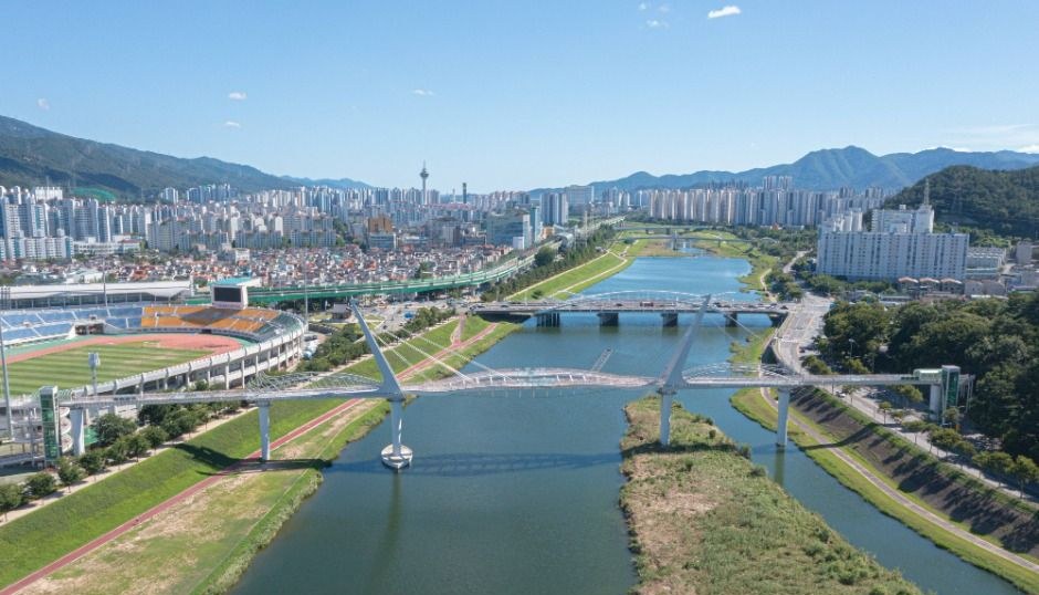 양산천이 흐르는 양산 시가지와 둔치, 멀리 산이 보이는 전경