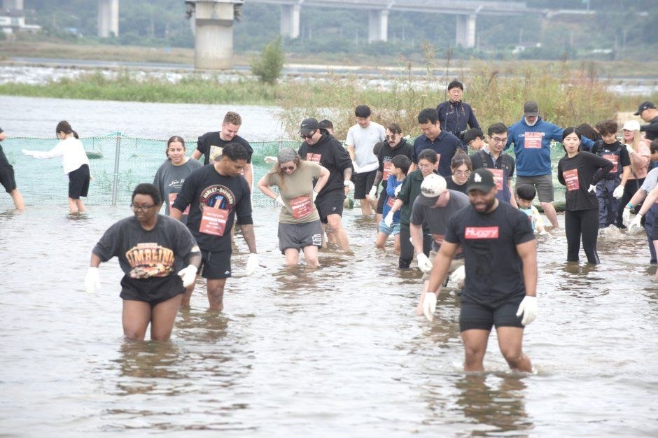 남대천에 들어가 연어를 잡으려는 참가자들이 물속에서 걸어가는 양양송이연어축제 체험