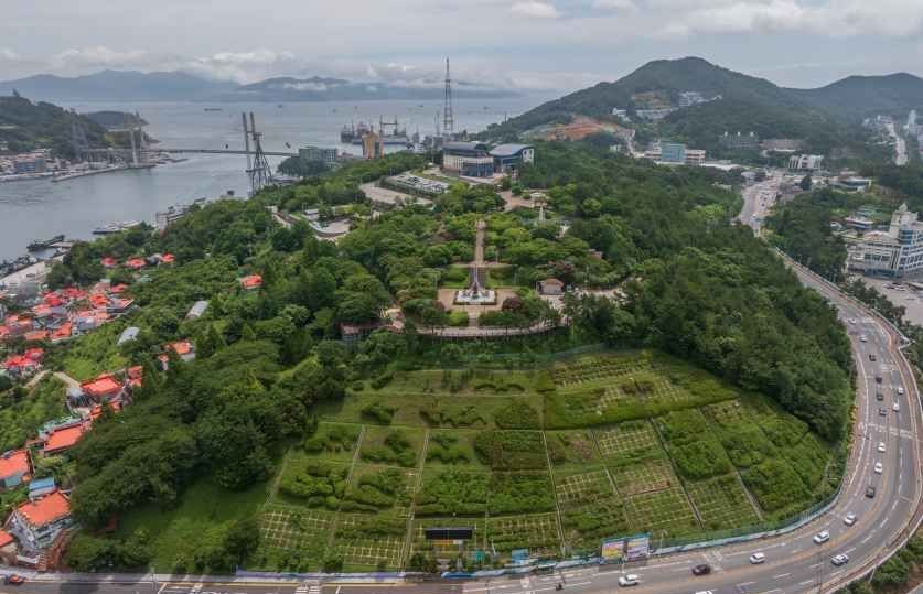 공원 언덕과 주변 해안, 도로가 내려다보이는 여수 돌산 지역 항공 전경